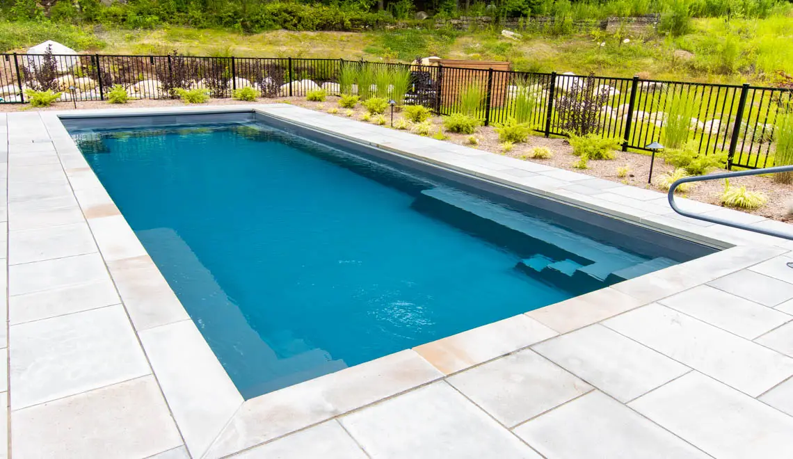 The Supreme fiberglass pool corner entry steps and bench seating close-up in Graphite Grey