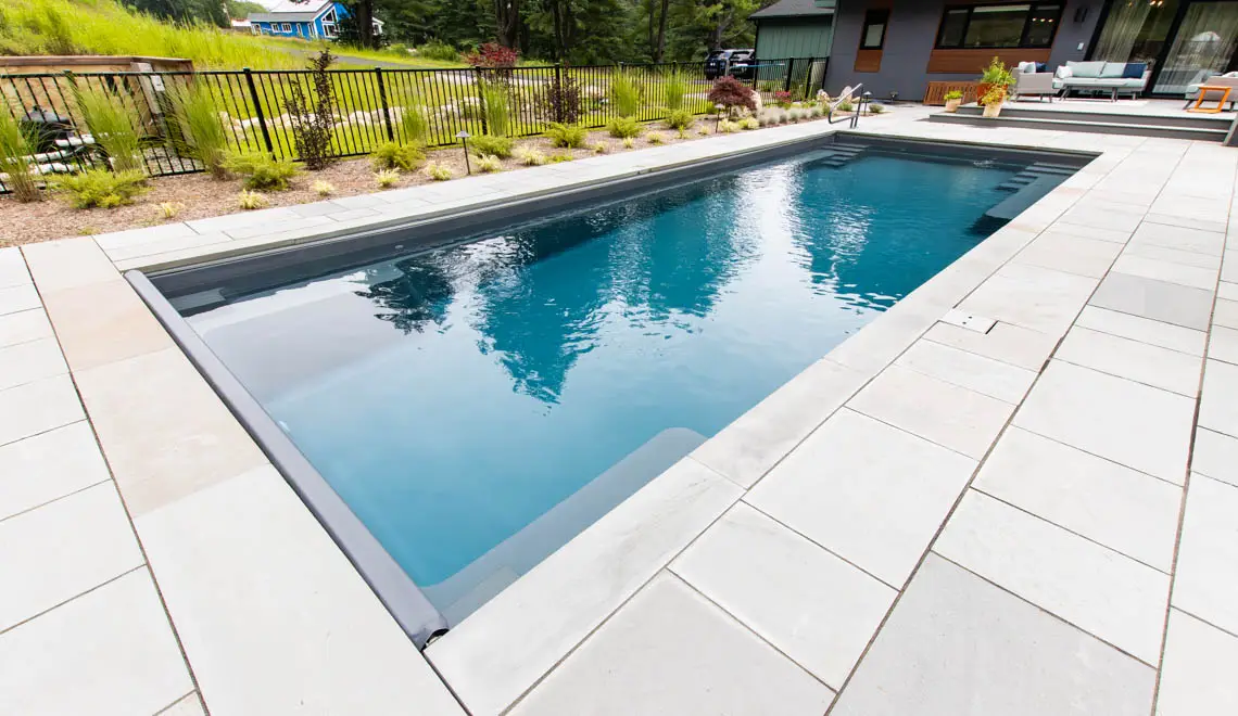 The Supreme fiberglass pool side angle showing full swim channel length in Graphite Grey