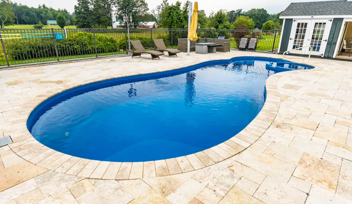 Leisure Pools Allure inground freeform swimming pool with deep-end swim out bench in Sapphire Blue