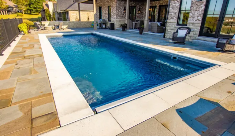 Leisure Pools Pinnacle fiberglass pool in Graphite Grey with large patio and open backyard