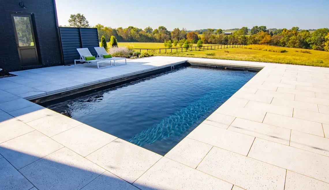 Leisure Pools Supreme inground fiberglass swimming pool with generous bench seats in Graphite Grey