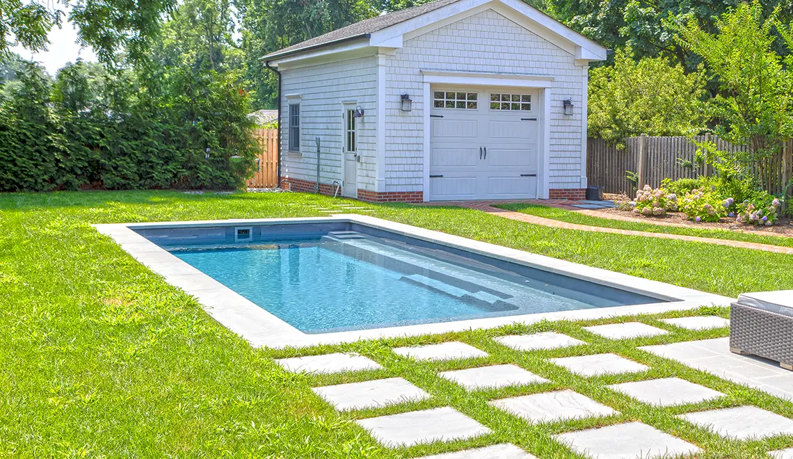 The Reflection fiberglass pool generous splash deck and full length bench seat