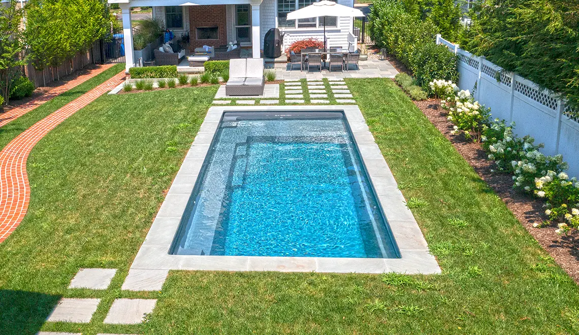 The Reflection fiberglass pool generous splash deck and full length bench seat