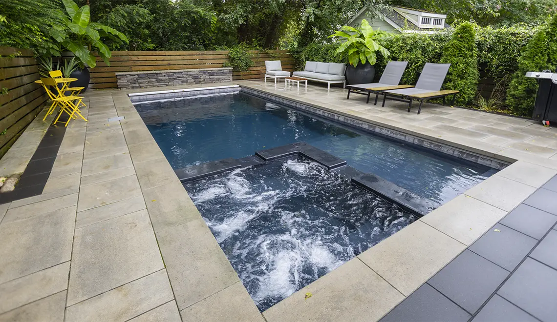 Leisure Pools Limitless fiberglass swimming pool with built-in spa and splash deck
