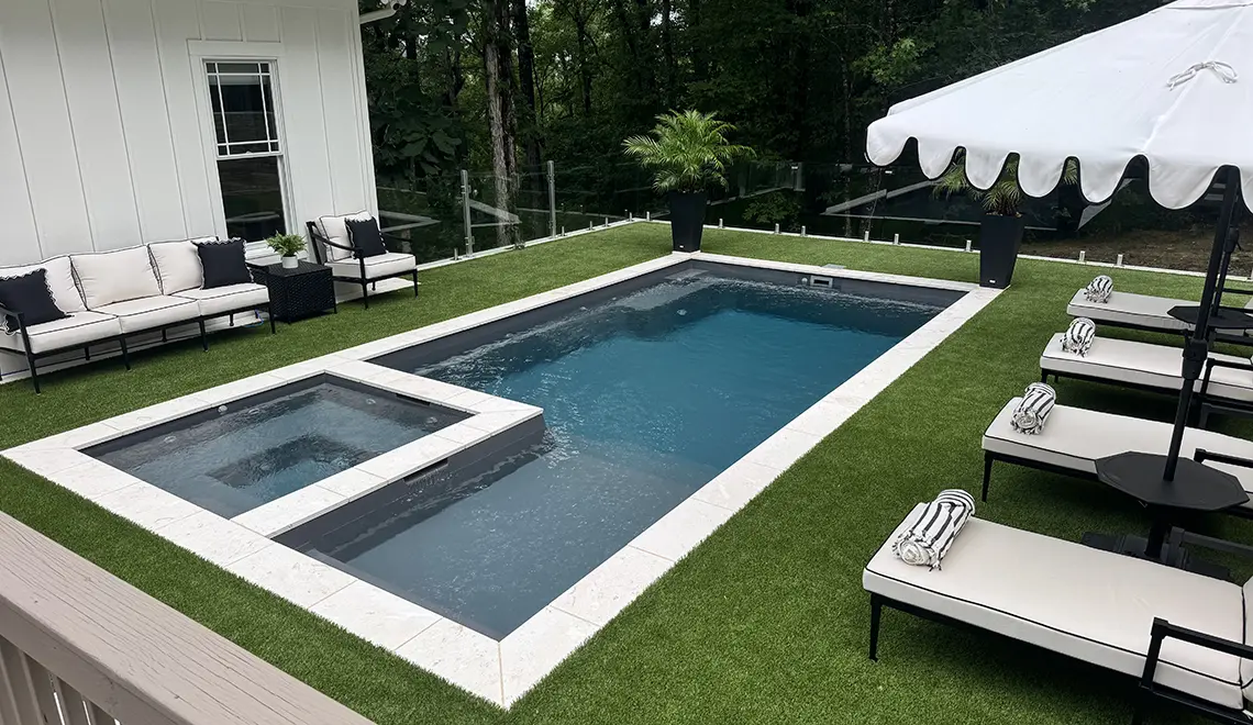 Leisure Pools Limitless fiberglass swimming pool with built-in spa and splash deck