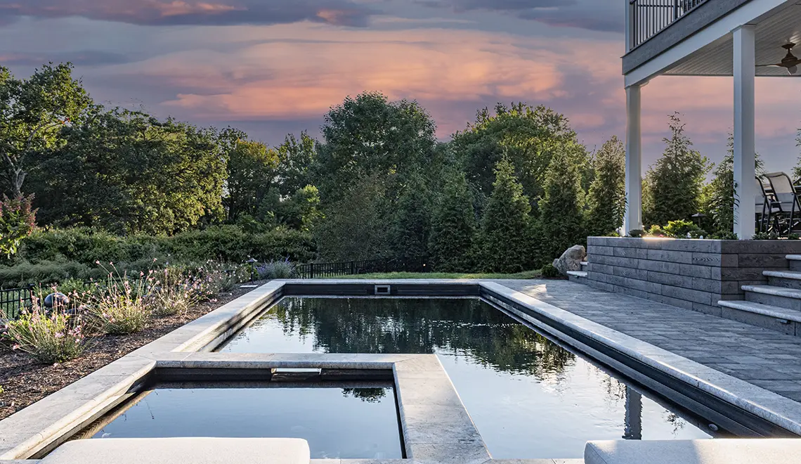 Leisure Pools Limitless fiberglass swimming pool with built-in spa and splash deck