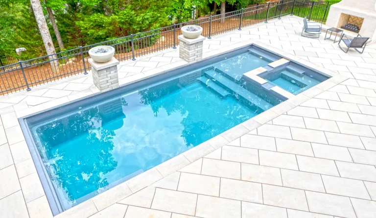 Leisure Pools Limitless fiberglass swimming pool with built-in spa and splash deck