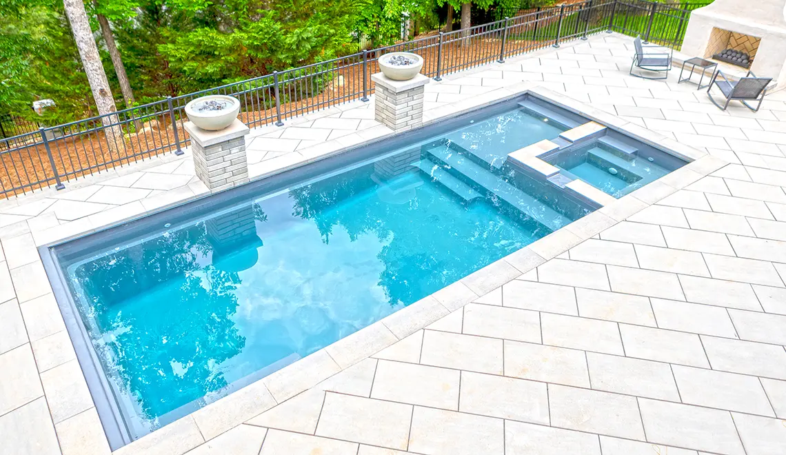 Leisure Pools Limitless fiberglass swimming pool with built-in spa and splash deck