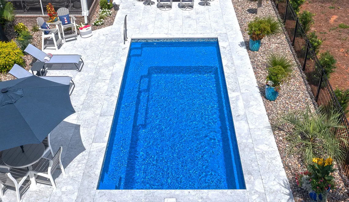 The Reflection fiberglass pool generous splash deck and full length bench seat