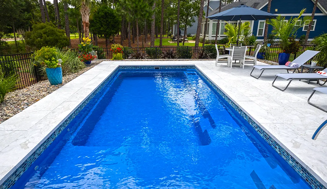 The Reflection fiberglass pool generous splash deck and full length bench seat