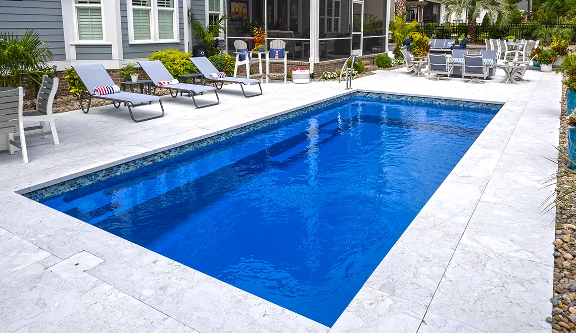 The Reflection fiberglass pool generous splash deck and full length bench seat