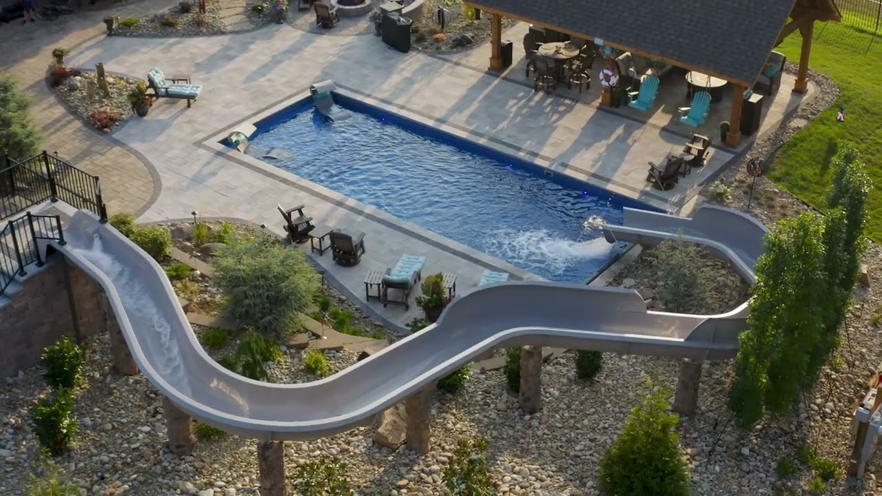 The Pinnacle fiberglass pool overhead view with winding pool slide and stone paver surround