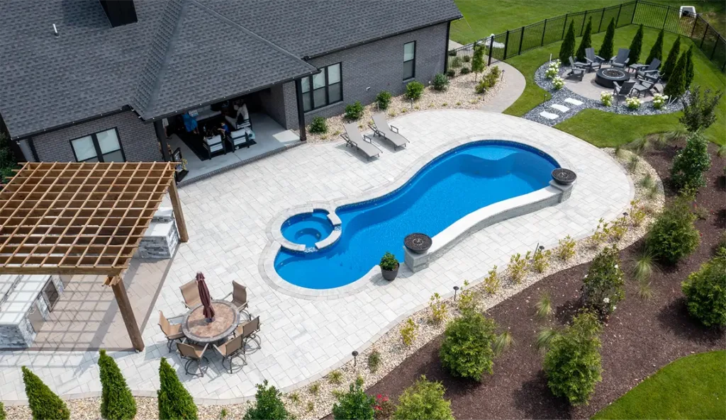 Leisure Pools Allure fiberglass pool aerial view showing graceful freeform curves in Sapphire Blue