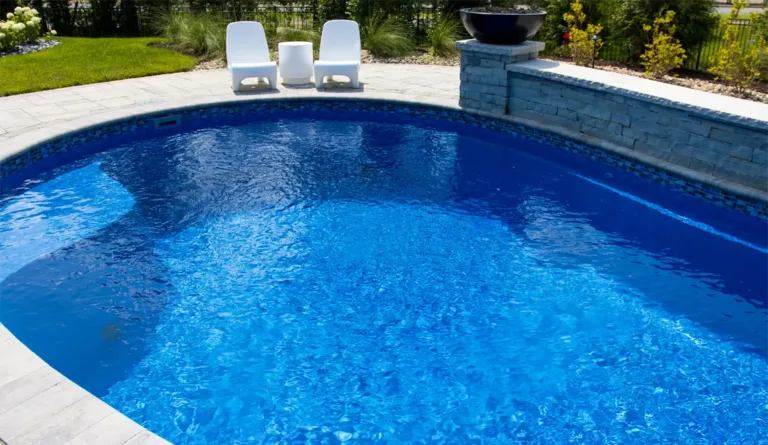 The Allure fiberglass pool overhead view with poolside lounge chairs in Sapphire Blue