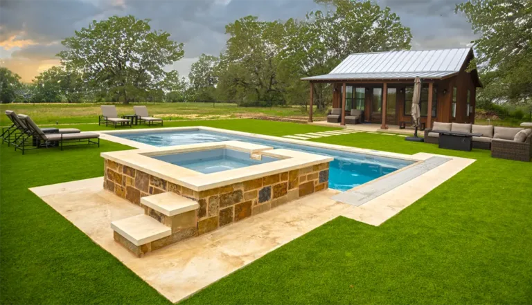 Leisure Pools Wave fiberglass pool with stone pavilion and open country landscape
