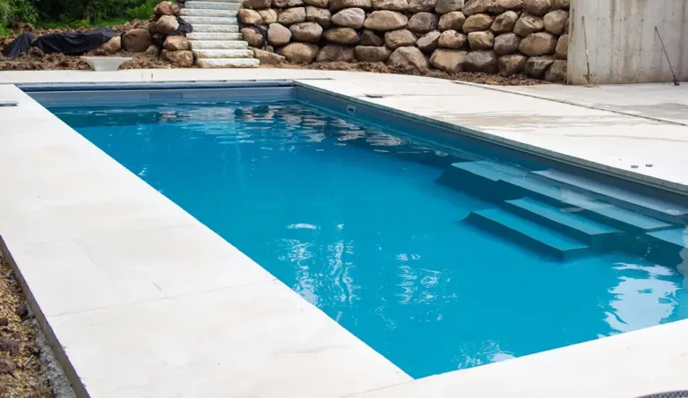 The Grand fiberglass pool shallow end bench seating and open swim corridor