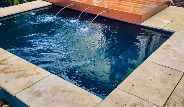 Leisure Pools Fiji Plunge fiberglass pool with arc waterfall feature and timber deck