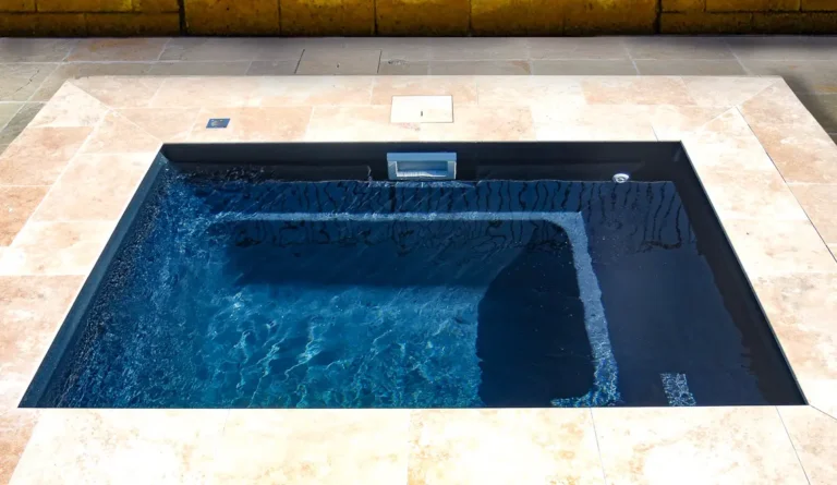 The Fiji Plunge fiberglass plunge pool in with spillover water feature and stone surround