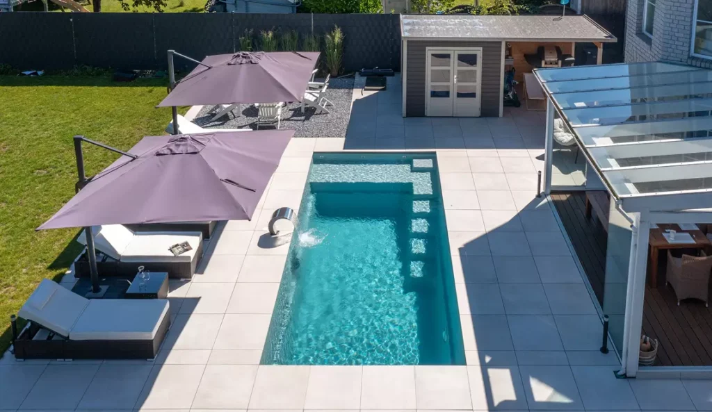 Leisure Pools Precision fiberglass pool aerial view with pool cabana and patio surround