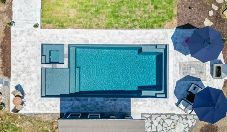 Leisure Pools Ultimate 40 fiberglass pool aerial view with mosaic stone surround