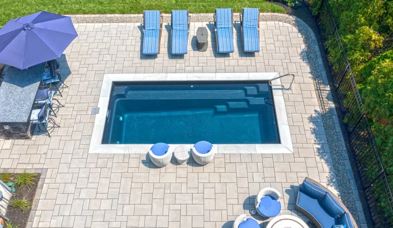 The Harmony 20 fiberglass pool overhead view with decorative paver grid surround in Ebony Blue