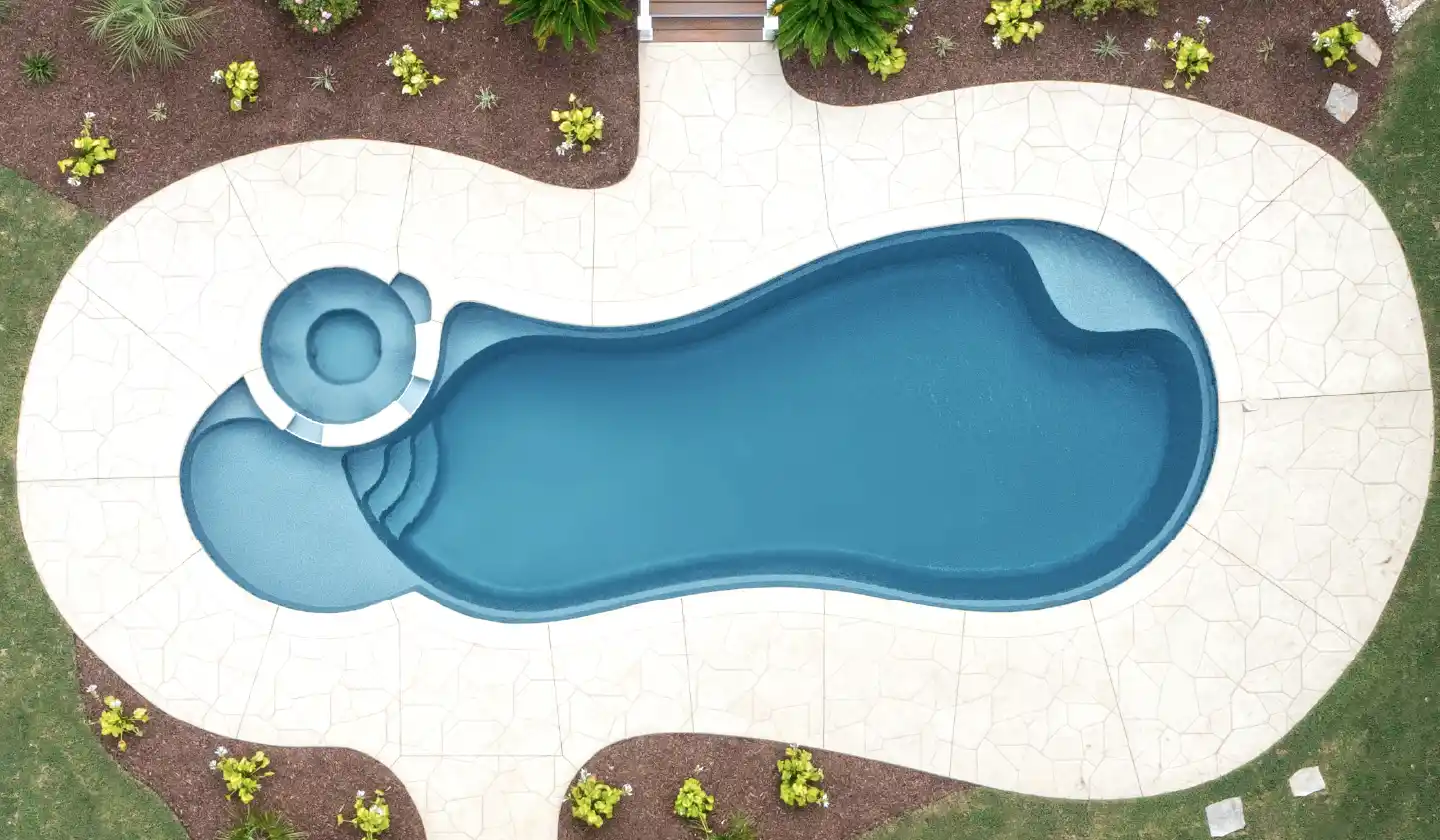 Overhead view of The Allure™ fiberglass pool in Graphite Grey, with an integrated spa adjoining a broad shallow deck.