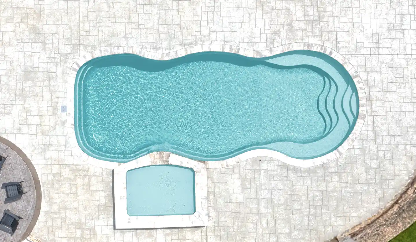 The Caribbean™ shown in Diamond Sand, featuring a curved swimming area beside a separate square spa.