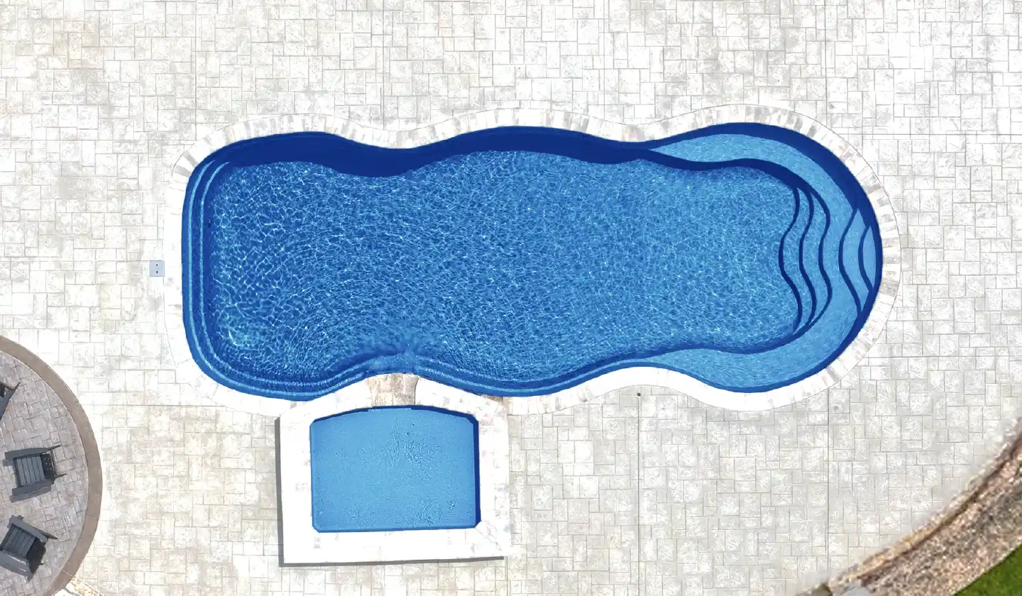 Color preview of The Caribbean™ in Sapphire Blue, showing a freeform pool framed by light paving and a curved patio edge.