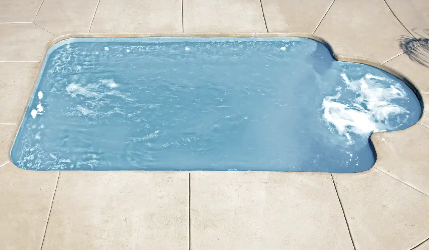 The Courtyard Roman™ shown in Shimmer Sky, featuring rounded corners and a curved seating recess at the end.