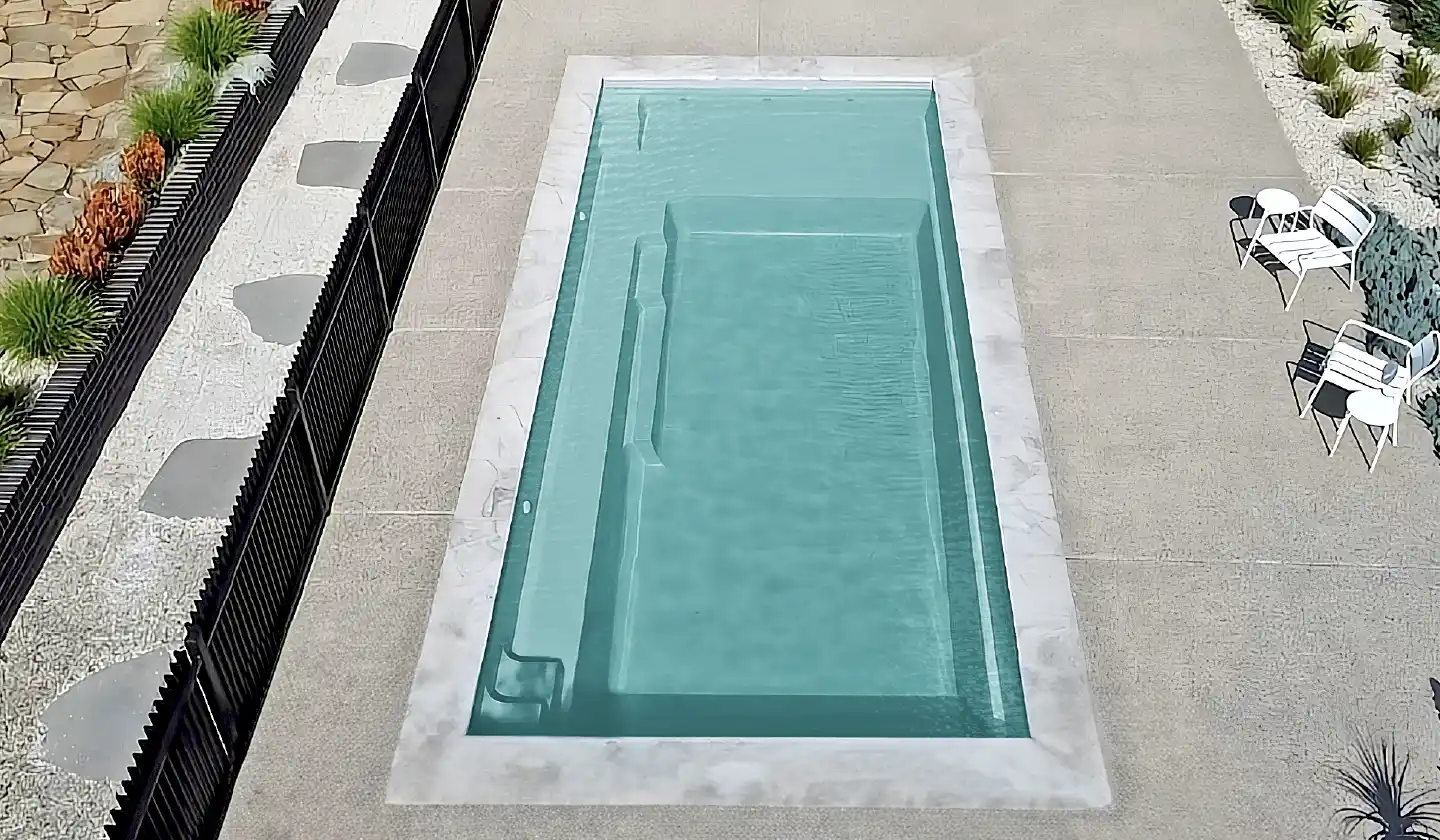 Elevated view showing The Elite™ in Diamond Sand, with a shallow lounging shelf at one end of the straight-sided pool.