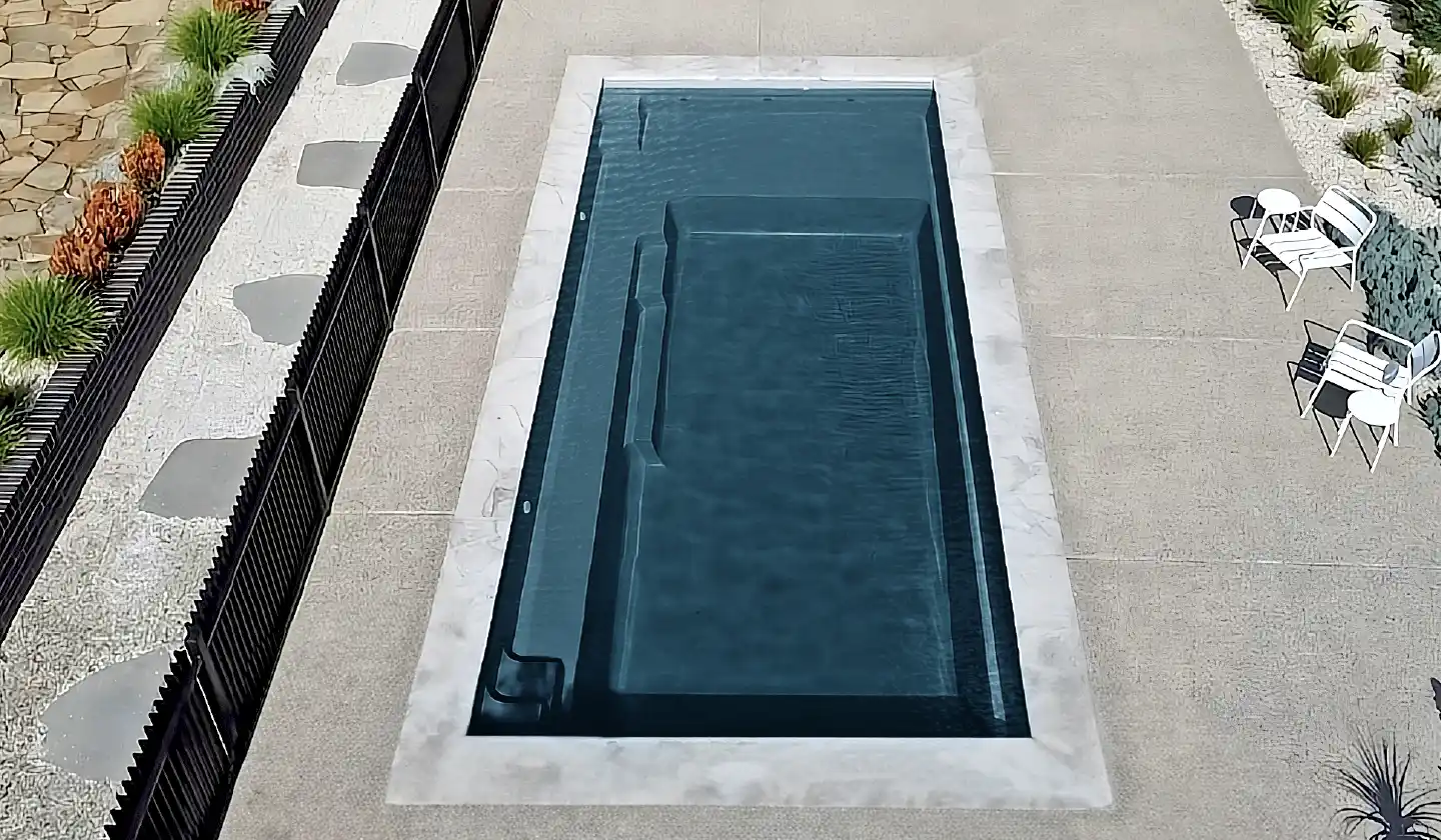 The Elite™ in Ebony Blue, a fiberglass pool with a rectangular layout, generous splash deck and entry steps.