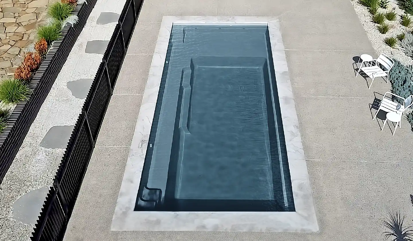 The Elite™ shown in Graphite Grey, featuring a long swim area framed by pale coping and a paved patio.