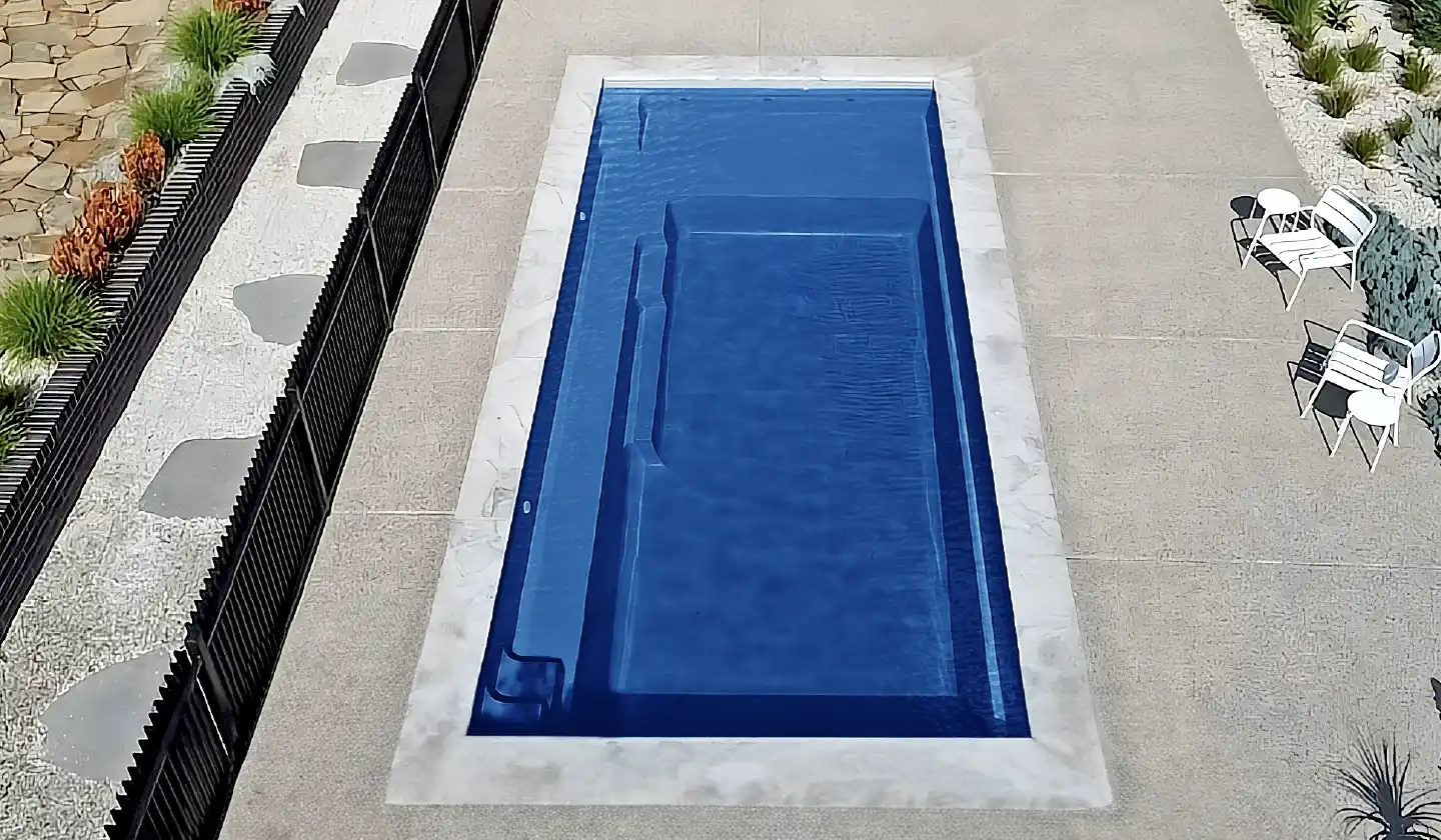 Elevated view of The Elite™ fiberglass pool in Sapphire Blue, with a broad shallow end adjoining an unobstructed swimming corridor.