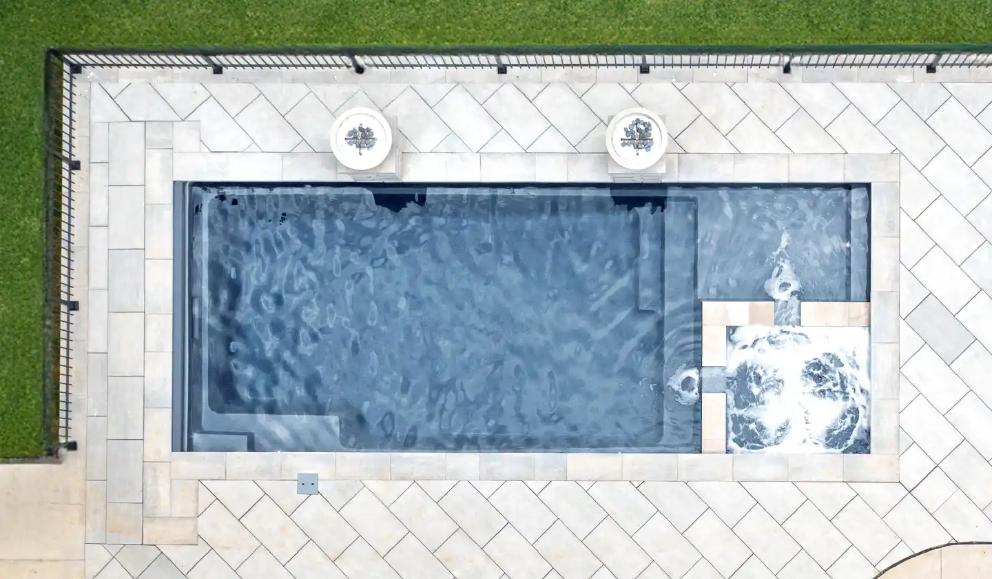 The Limitless™ shown in Graphite Grey, featuring a shallow deck adjoining the spa at one end of the pool.