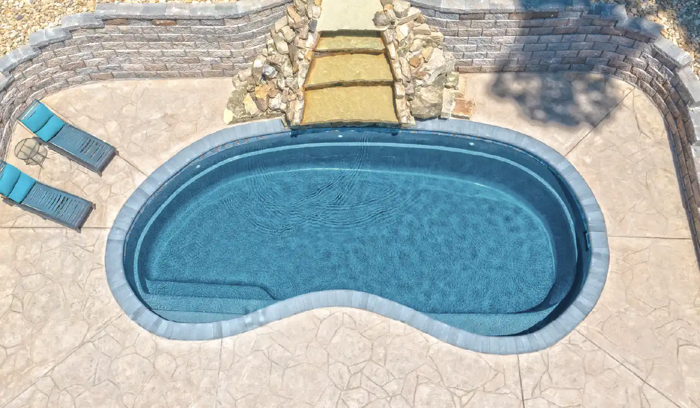Color preview of The Tuscany™ in Graphite Grey, showing a sweeping curved edge around the open swimming area.
